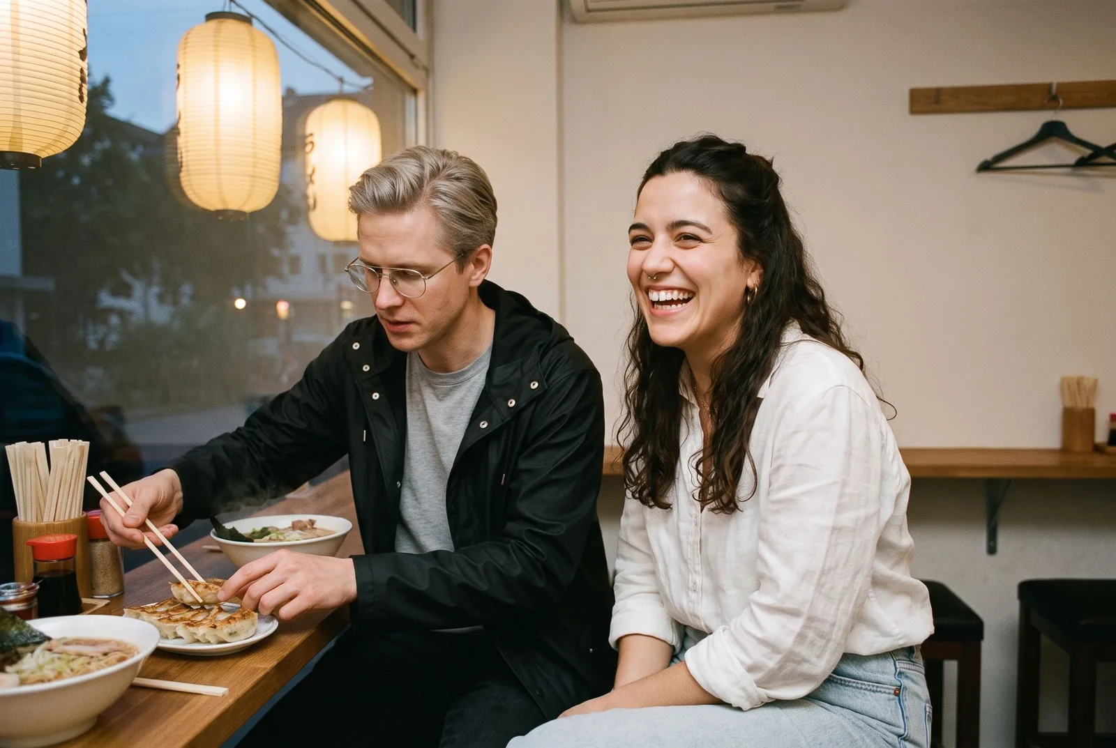 Zwei Freunde mit Ramen und Gyoza am Tresen eines japanischen Restaurants im Düsseldorfer Japanviertel